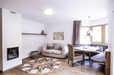 a living room with a couch and a table at Erika Suites & Lofts Chalet in Stanghe