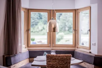 a living room with two windows and a table at Erika Suites & Lofts Chalet in Stanghe