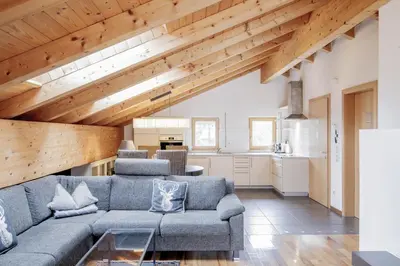 a living room with a gray couch and wooden ceilings at Erika Suites & Lofts Chalet in Stanghe