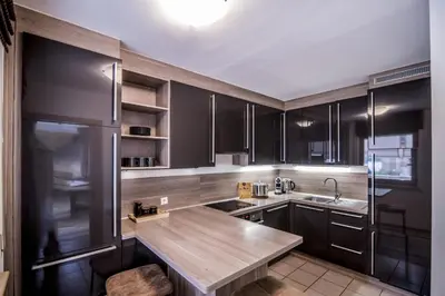 a kitchen with black cabinets and a wooden counter top at Erika Suites & Lofts Chalet in Stanghe