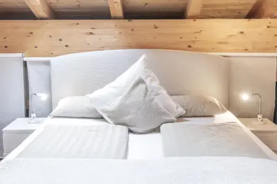 a bedroom with a white bed with white pillows at Erika Suites & Lofts Chalet in Stanghe