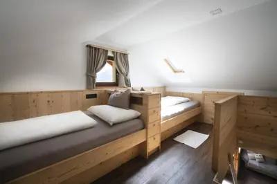 two beds in a room with wooden cabinets at Apartments Rondula in Santa Cristina in Val Gardena