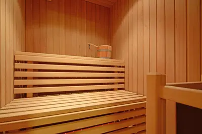 a sauna with a bench and a bucket in it at Apartments Rondula in Santa Cristina in Val Gardena