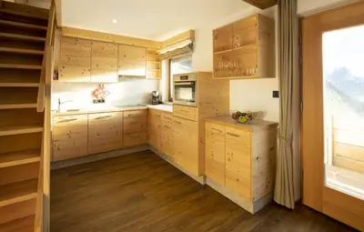 a kitchen with wooden cabinets and a window at Apartments Rondula in Santa Cristina in Val Gardena