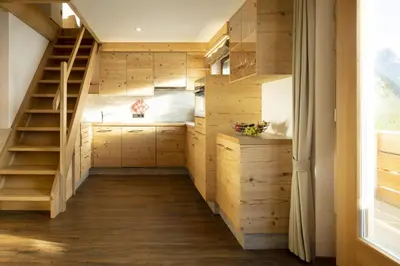 a tiny house with a staircase and a kitchen at Apartments Rondula in Santa Cristina in Val Gardena