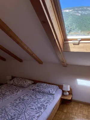 a bedroom with a bed and a large window at Platzlhof in Appiano sulla Strada del Vino