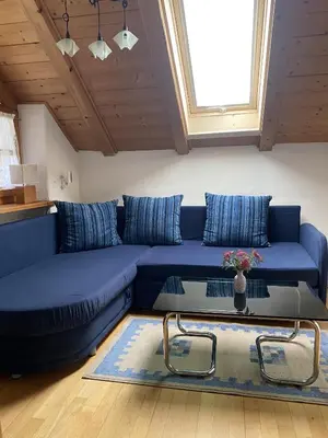 a blue couch in a living room with a table at Platzlhof in Appiano sulla Strada del Vino