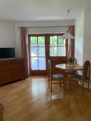 a living room with a table and chairs and a television at Platzlhof in Appiano sulla Strada del Vino