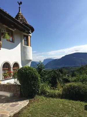 a white house with a view of the mountains at Platzlhof in Appiano sulla Strada del Vino