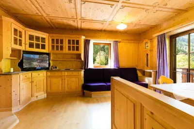 a kitchen with a couch and a tv in a room at Ferienhaus Daniel in Racines
