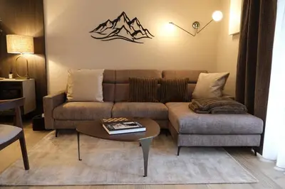 a living room with a couch and a table at GARDEN SUITE appartment in Valdaora di Sopra