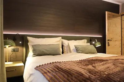 a bedroom with a large bed with a wooden headboard at GARDEN SUITE appartment in Valdaora di Sopra
