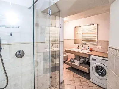 a bathroom with a shower and a washing machine at Apartment Ciasa Tella by Interhome in Moena