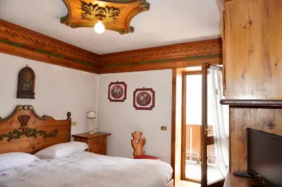 a bedroom with a bed and a flat screen tv at Alverà Luxury apartment - centro Cortina d'Ampezzo in Cortina dʼAmpezzo