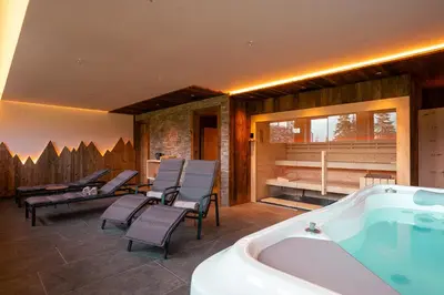 a bathroom with a tub and chairs and a swimming pool at Ferienhaus Morx Puite in Moso