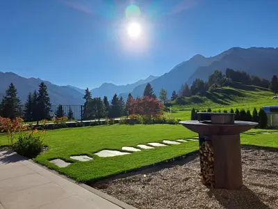 a bird bath in a garden with mountains in the background at Ferienhaus Morx Puite in Moso