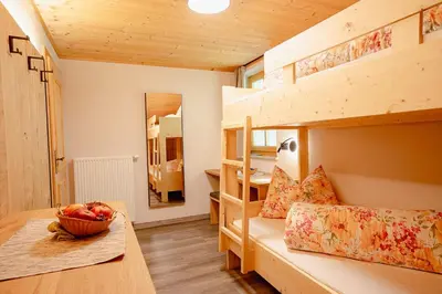 a room with bunk beds with a bowl of fruit on a table at Ferienhaus Morx Puite in Moso