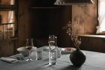 a table with two glasses of wine and a plate of food at South Tyrol Lodge With Mountain Views in Villandro
