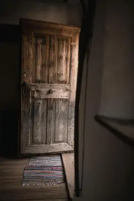 an old wooden door in a room with a rug at South Tyrol Lodge With Mountain Views in Villandro