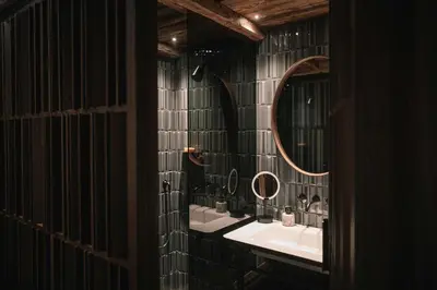 a bathroom with a sink and two mirrors at South Tyrol Lodge With Mountain Views in Villandro