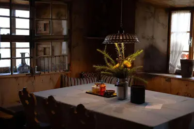 a table with a vase of flowers on it at South Tyrol Lodge With Mountain Views in Villandro