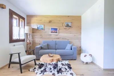 a living room with a blue couch and a table at Ruoibes 17 in San Vito di Cadore