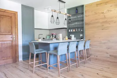 a kitchen with a blue island with bar stools at Ruoibes 17 in San Vito di Cadore