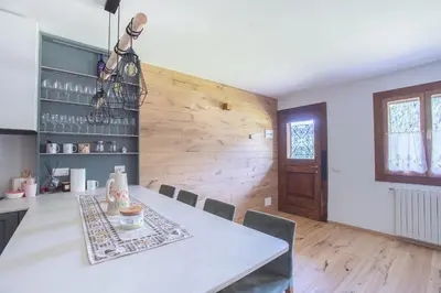 a dining room with a table and chairs and a wooden wall at Ruoibes 17 in San Vito di Cadore