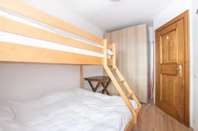 a bedroom with a bunk bed with a ladder at Ruoibes 17 in San Vito di Cadore