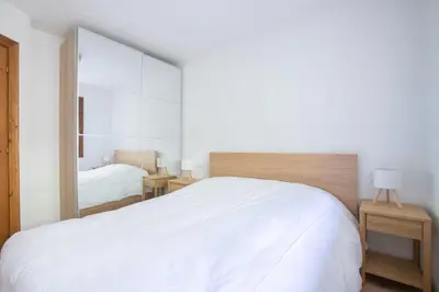 a bedroom with a large white bed and a mirror at Ruoibes 17 in San Vito di Cadore