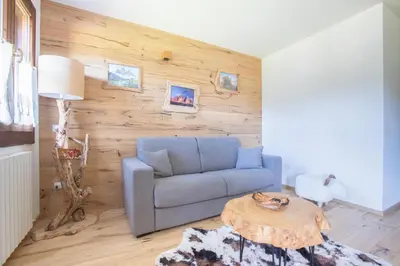 a living room with a blue couch and a table at Ruoibes 17 in San Vito di Cadore