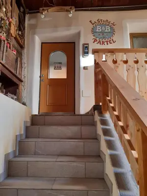 a set of stairs leading to the door of a building at BeB LA STUBE DEI PARTEL in Ziano di Fiemme