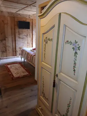 a bedroom with a door with flowers painted on it at BeB LA STUBE DEI PARTEL in Ziano di Fiemme