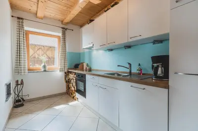 a kitchen with white cabinets and a sink at Ferienwohnungen Wiesbauer in Schenna