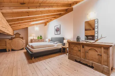 a large bedroom with a bed and a large mirror at Ferienwohnungen Wiesbauer in Schenna