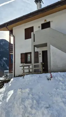 a building with a pile of snow in front of it at AF Casa Vacanze in Campitello di Fassa