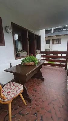 a wooden table and a chair on a patio at AF Casa Vacanze in Campitello di Fassa