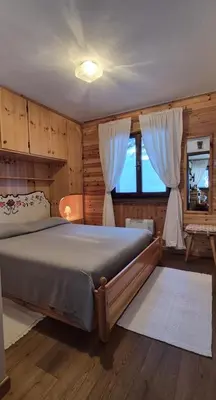 a bedroom with a large bed and a window at AF Casa Vacanze in Campitello di Fassa