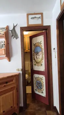 a bathroom with a door with a painting on it at AF Casa Vacanze in Campitello di Fassa