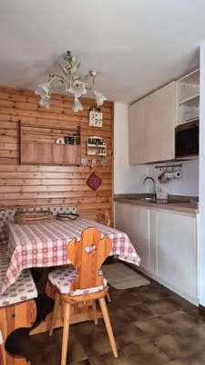 a kitchen with a table and a chair in it at AF Casa Vacanze in Campitello di Fassa