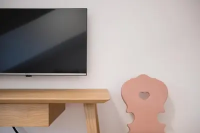 a flat screen tv sitting next to a wooden table at Kreuz Appartement in Rifiano