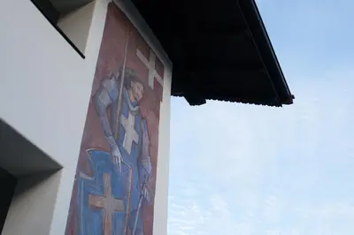 a cross painted on the side of a building at Kreuz Appartement in Rifiano