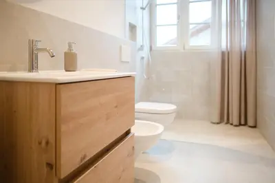 a bathroom with a sink and a toilet and a window at Kreuz Appartement in Rifiano