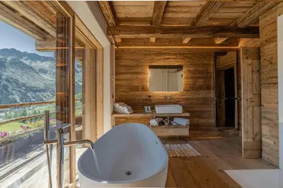 a bathroom with a white tub and a window at Chalet Lumiere by Elite Villas in Livinallongo del Col di Lana