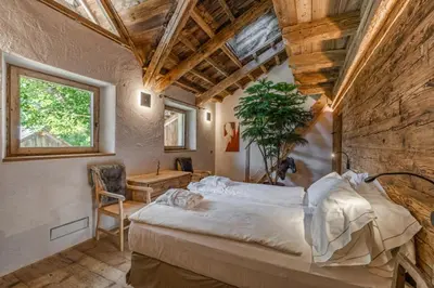 a bedroom with a large bed in a room at Chalet Lumiere by Elite Villas in Livinallongo del Col di Lana