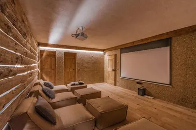 a living room with a couch and a projection screen at Chalet Lumiere by Elite Villas in Livinallongo del Col di Lana