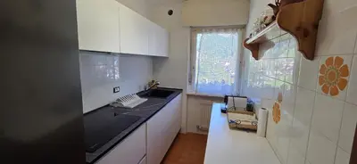 a kitchen with white cabinets and a black counter top at Casa Scacciapensieri in Pera