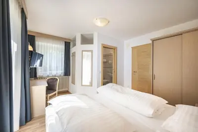 a bedroom with a large white bed in a room at Pivan Apartments in Selva di Val Gardena