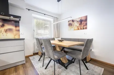 a kitchen and dining room with a wooden table and chairs at Pivan Apartments in Selva di Val Gardena