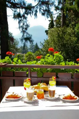 a table with plates of food and drinks on it at Living Apartments Morgenstern in Merano